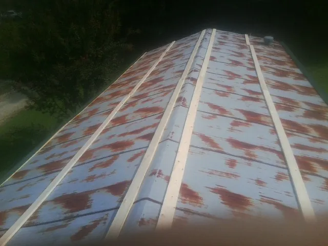 Rusted metal roof panels with new wood purlins before replacement — Storm Damage Roof Repair in Melvindale by Roofing Brothers