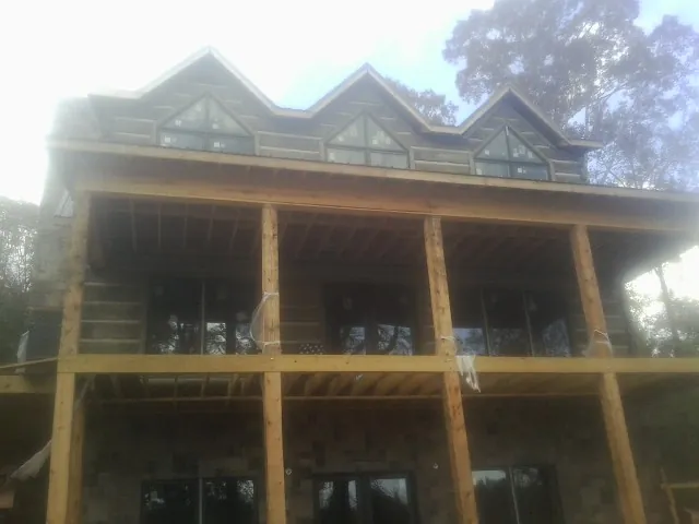 Dormers and porch framing on a large log home under construction — Roof Coating work by our crew in Melvindale