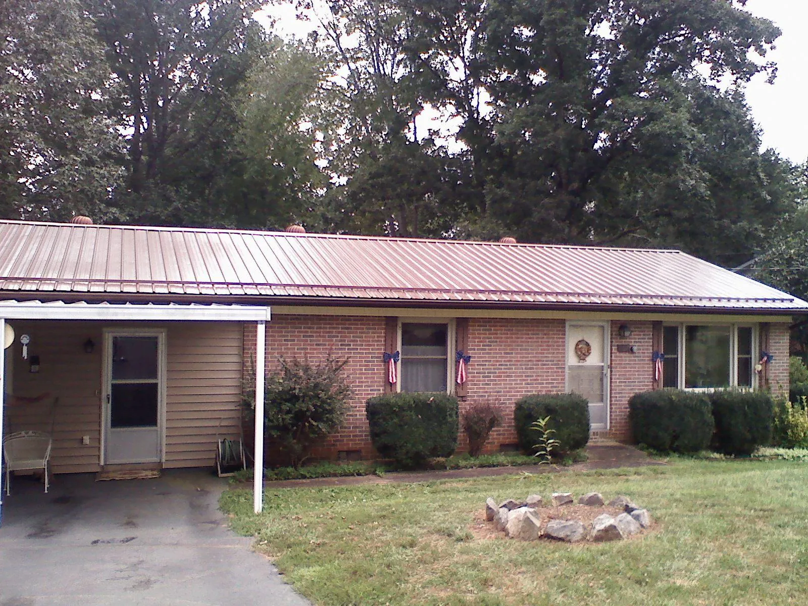 Bronze metal roof and carport on a brick ranch home — Roof Repair work by our crew in Melvindale