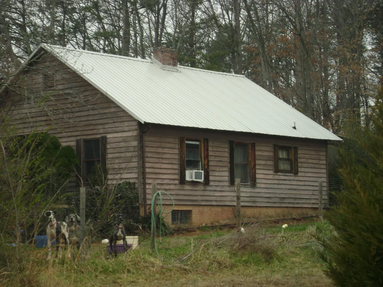 White metal roof on an old wood sided farmhouse, from a Metal Roof Installation job in Melvindale